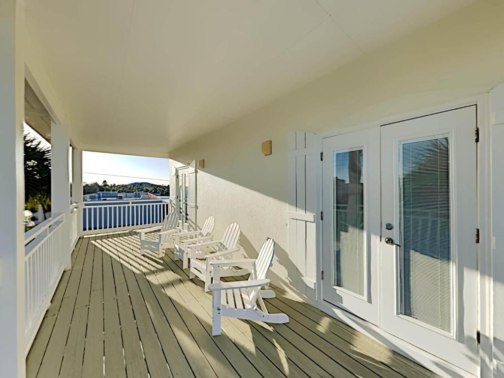a porch with white chairs and a view of the ocean at Changes In Latitude in Destin
