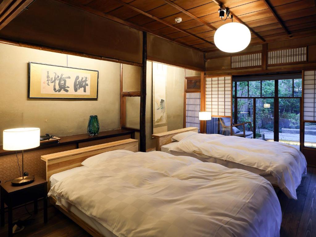 Postel nebo postele na pokoji v ubytování 古民家の宿宰嘉庵 TraditionalJapaniseHotel Saikaan