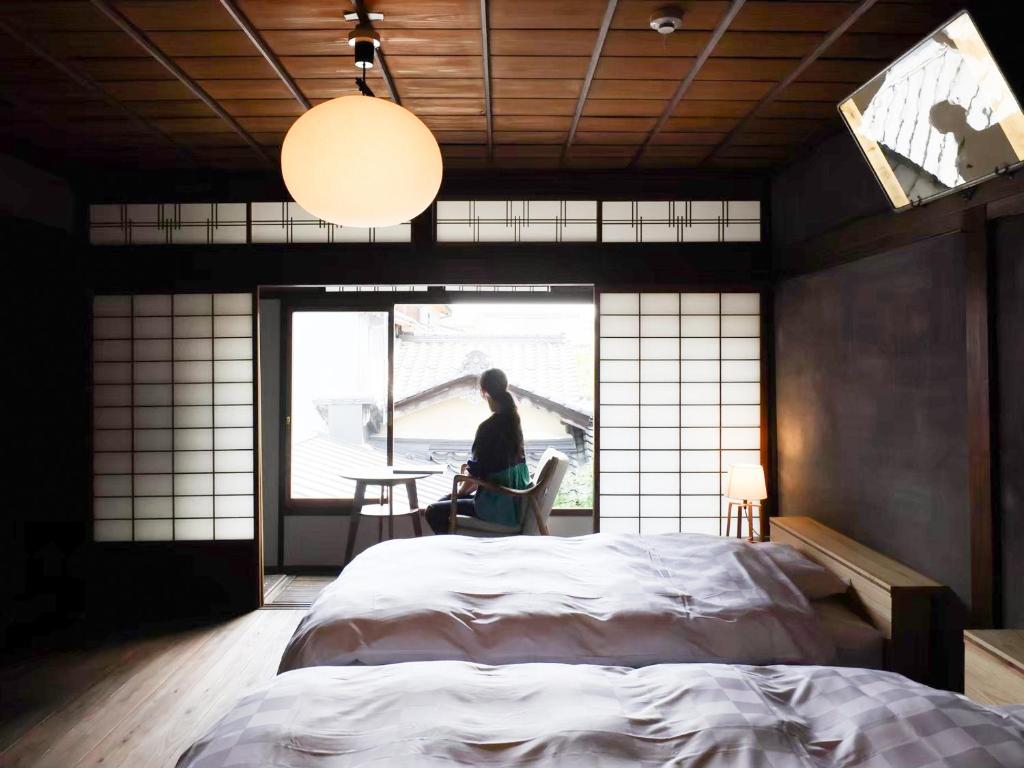 Postel nebo postele na pokoji v ubytování 古民家の宿宰嘉庵 TraditionalJapaniseHotel Saikaan