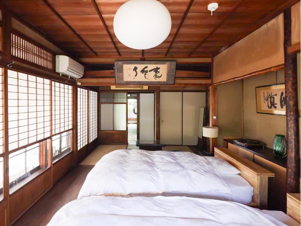 Postel nebo postele na pokoji v ubytování 古民家の宿宰嘉庵 TraditionalJapaniseHotel Saikaan