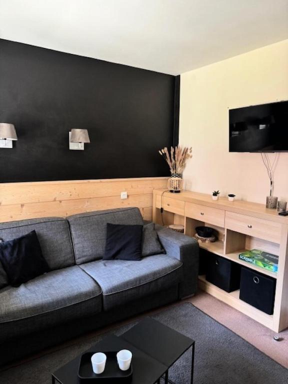 un salon avec un canapé et une télévision dans l'établissement Résidence Plagne Lauze - maeva Home - Studio 4 Personnes - Prestige MAE-2634, à Mâcot La Plagne