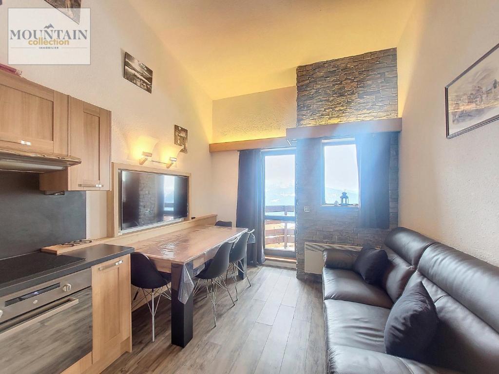 un salon avec un canapé et une table dans l'établissement Studio rénové près des pistes avec balcon et parking - FR-1-275-161, à La Rosière
