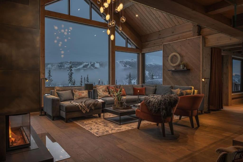 Una sala de estar con un sofá y una ventana grande. en Hyttekos Lodge, en Kvitfjell