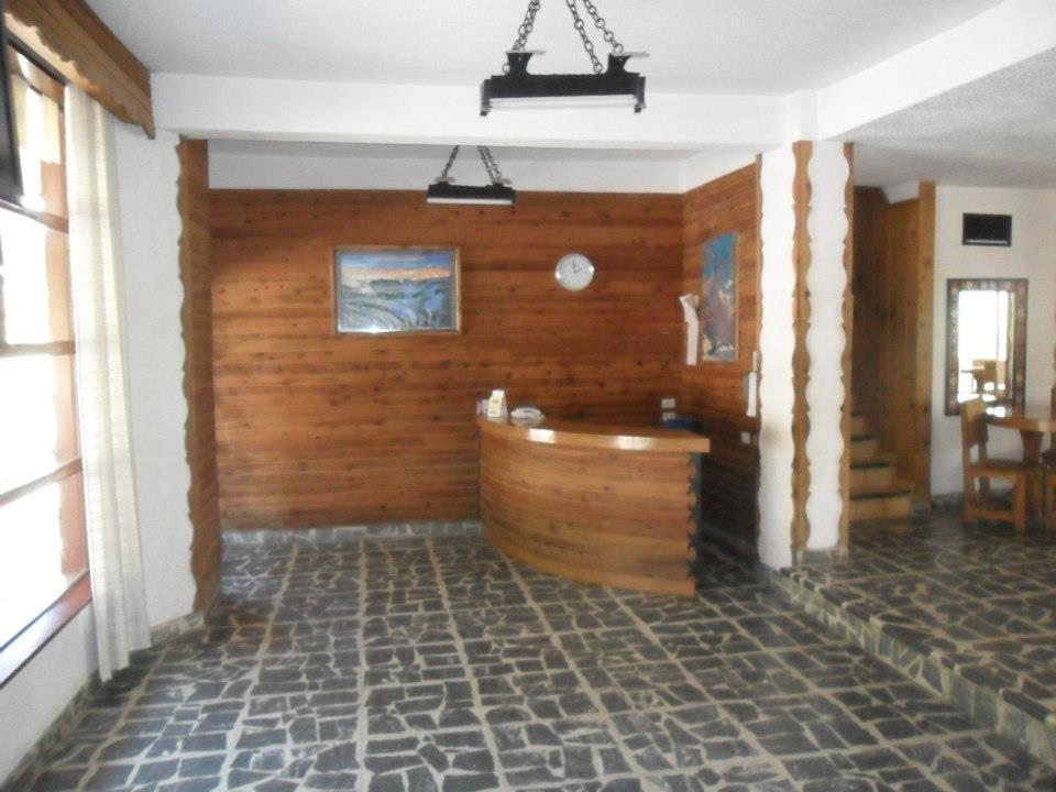 Habitación con pared de madera y bañera. en Hotel Panoramico Bariloche en San Carlos de Bariloche