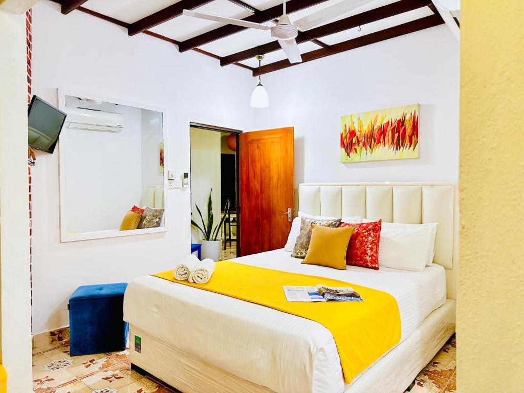 a bedroom with a bed with yellow and red pillows at B&B by Dorset in Negombo