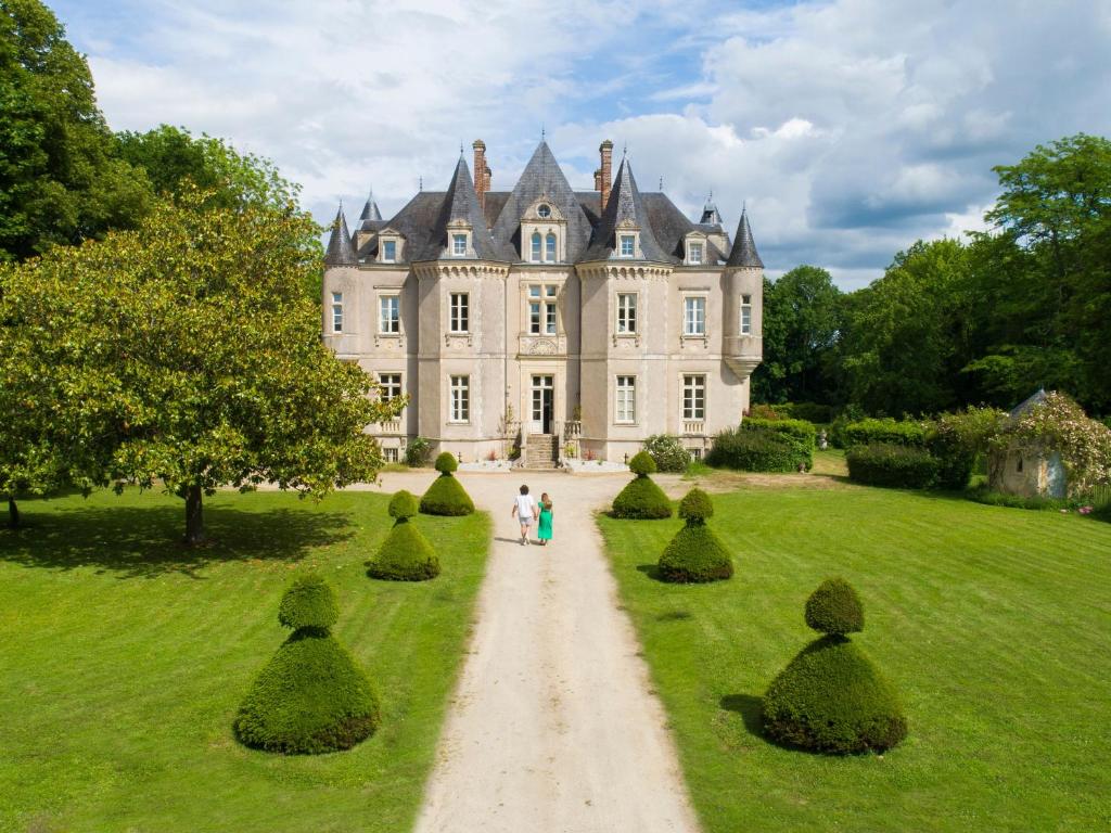 para spacerująca ścieżką przed zamkiem w obiekcie Grand Château Renaissance avec Parc, Piscine et Activités, Rénové en 2023 - FR-1-410-389 w mieście Vallon-sur-Gée