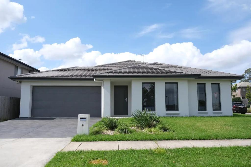 a house with a garage in a yard at Kellyvile Delight 5BrHouseParkingShopping Center in Kellyville