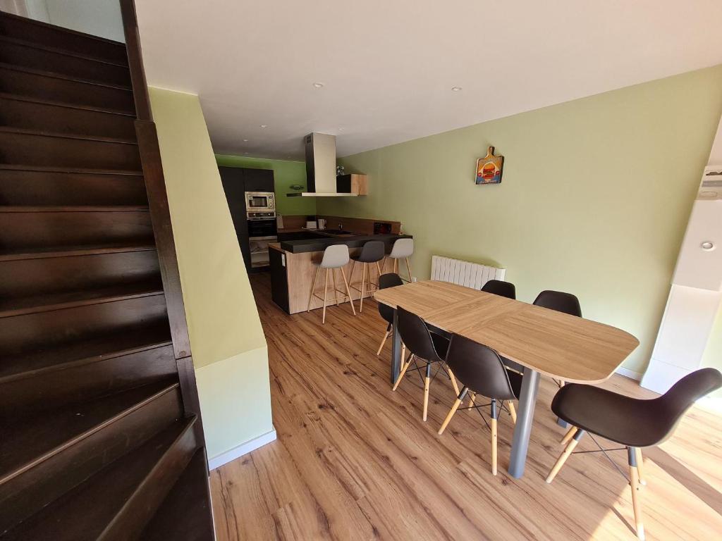 a dining room and kitchen with a wooden table and chairs at Gîte rénové près de Nancy et Metz, animaux admis - FR-1-584-296 in Lironville