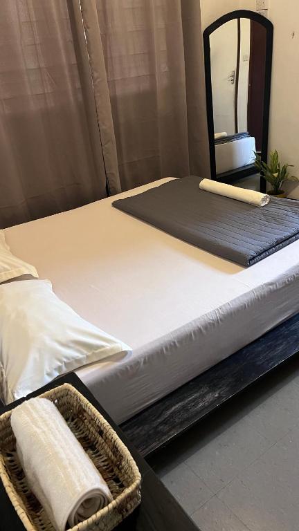 a bed in a room with a mirror at Mambo & Jambo Homestay in Mwanza