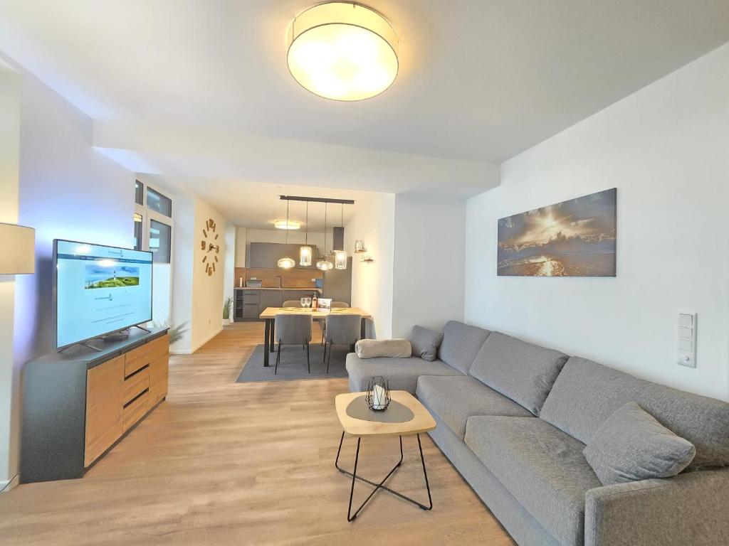 a living room with a couch and a flat screen tv at Ferienwohnung Meeresrauschen mit Sauna Haustier erlaubt in Norden