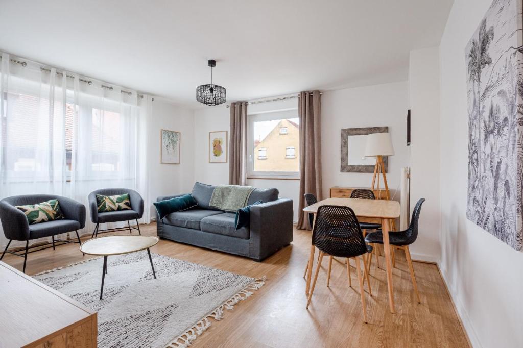 un salon avec un canapé, des chaises et une table dans l'établissement le schwendi, à Colmar