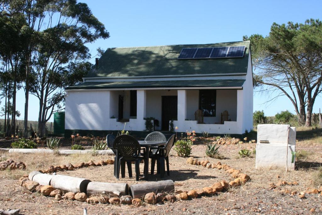 a house with a table and chairs in front of it at Infinity farm in Riversdale