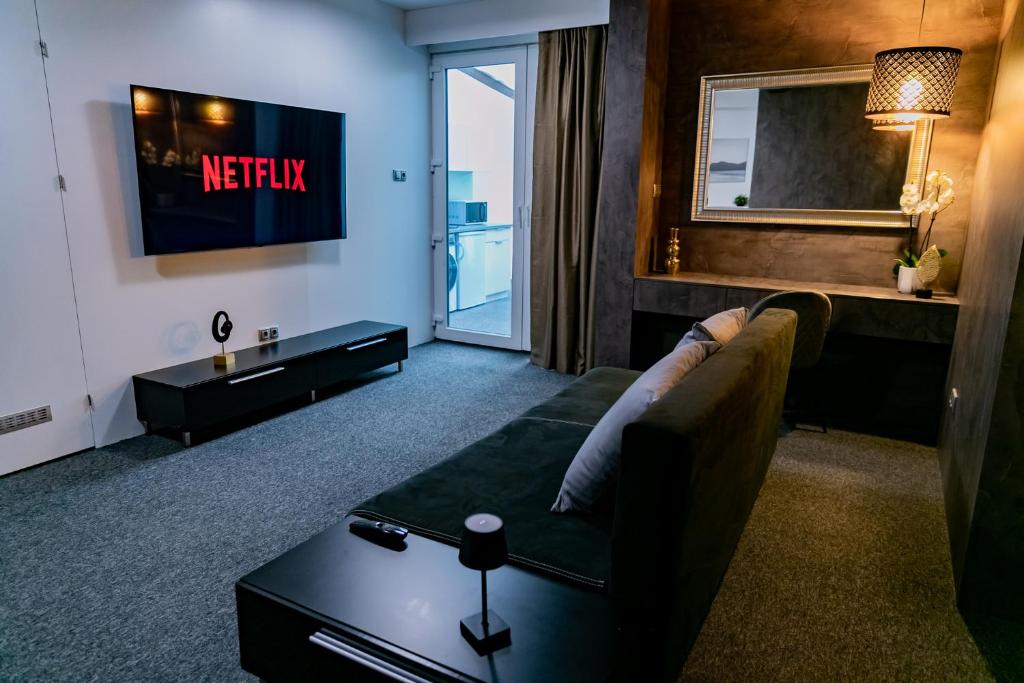 un salon avec un canapé et une télévision dans l'établissement Motel1- A megfizethető luxus!, à Dunaújváros