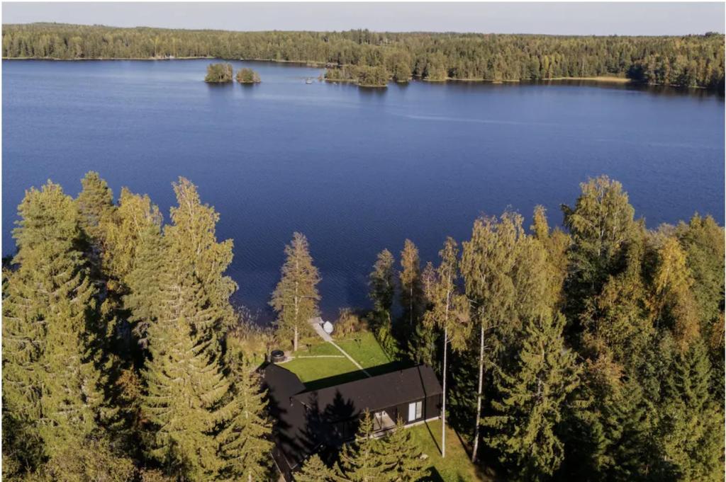 an aerial view of a house on the shore of a lake at Stay North - Villa Katajala in Hämeenlinna