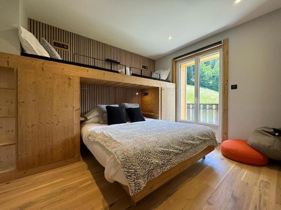 une chambre avec un grand lit et une grande fenêtre dans l'établissement Picot Apartment, à Morzine