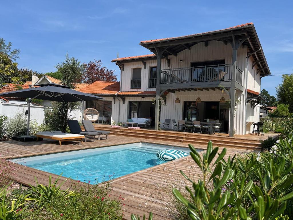 une villa avec piscine devant une maison dans l'établissement Spacieuse Villa sous les pins & piscine, à Andernos-les-Bains