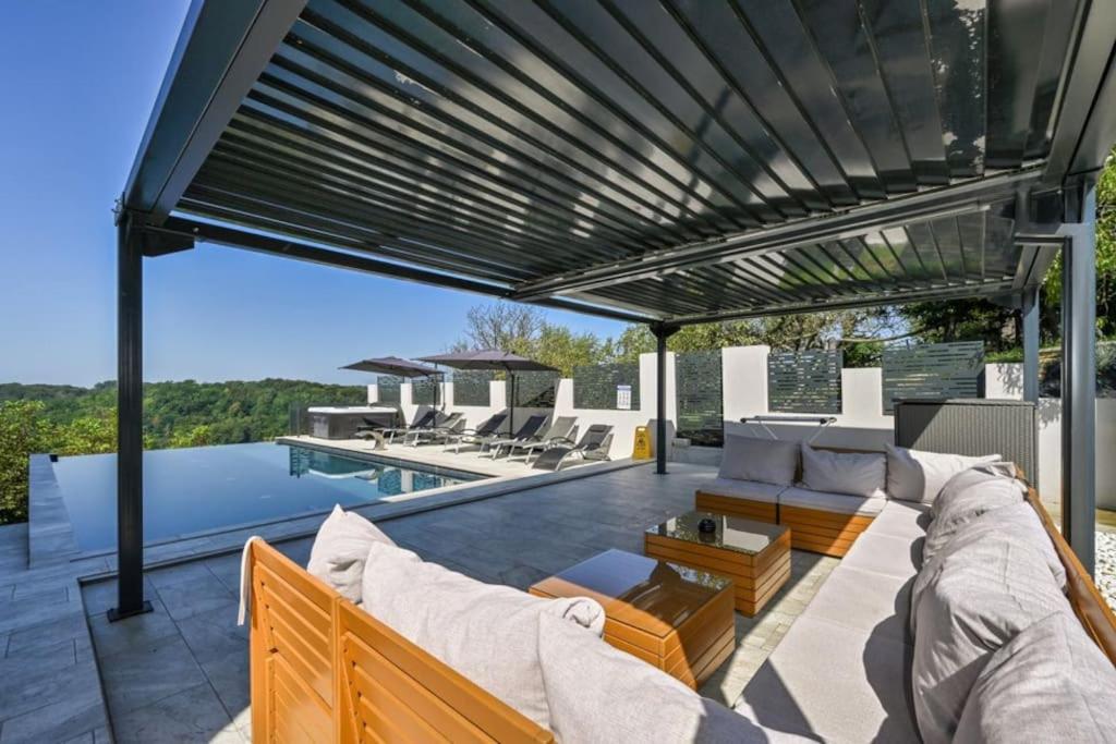 a patio with a couch and chairs and a swimming pool at Vila Ivka Holiday Resort in Donja Poljana