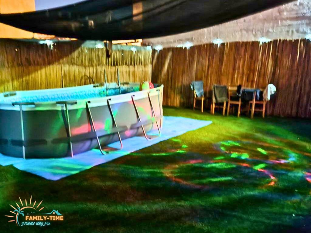 einen Pool in einem Zimmer mit einem Tisch und Stühlen in der Unterkunft Family-TIME בית פרטי לנופש משפחתי באילת in Eilat