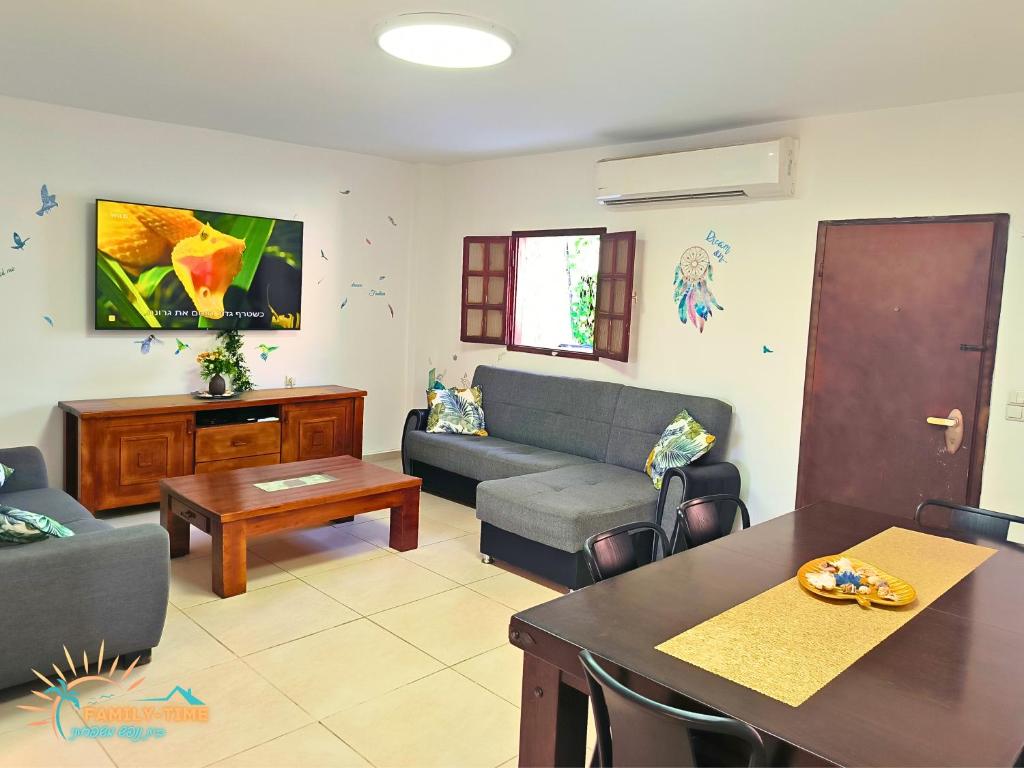 ein Wohnzimmer mit einer Couch und einem Tisch in der Unterkunft Family-TIME בית פרטי לנופש משפחתי באילת in Eilat