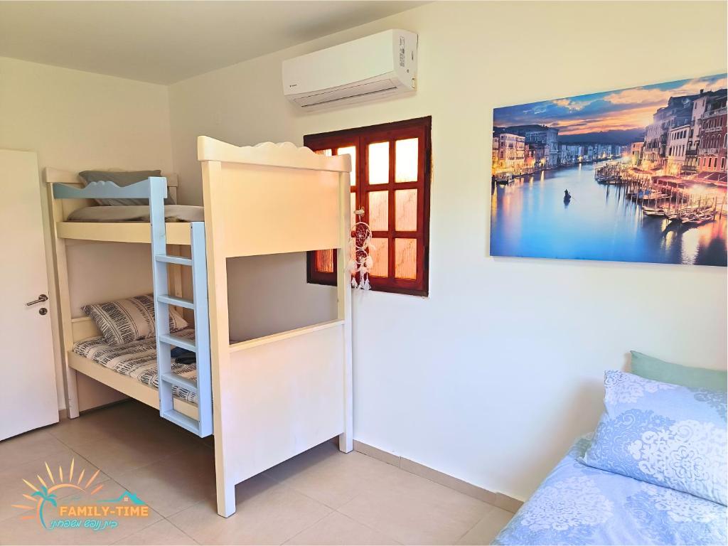 ein Schlafzimmer mit Etagenbetten und einem Fenster in der Unterkunft Family-TIME בית פרטי לנופש משפחתי באילת in Eilat