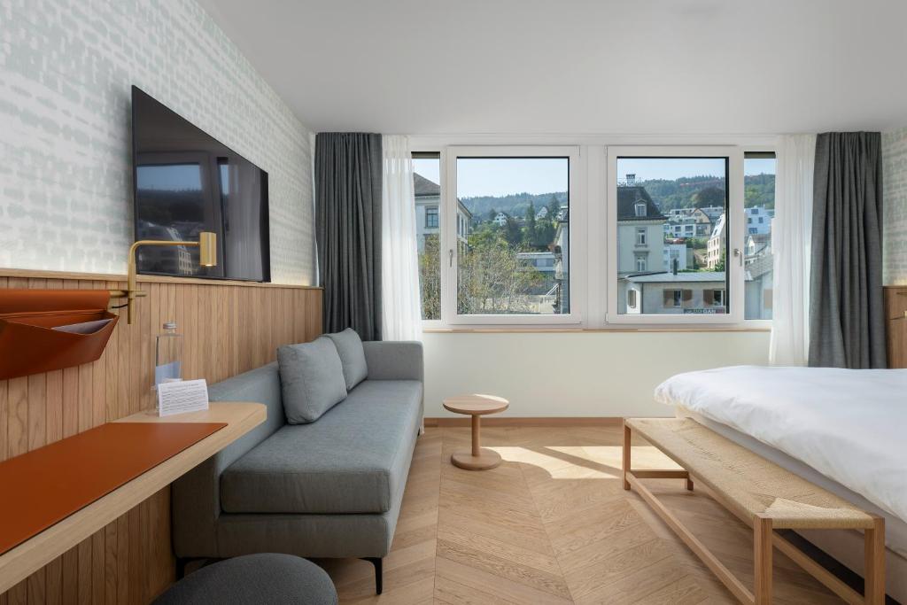 a hotel room with a bed and a couch at The Yarn in Horgen
