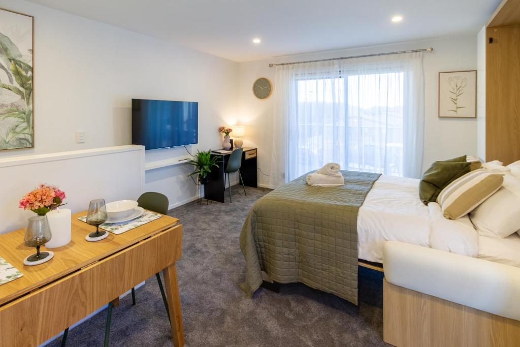 クライストチャーチにあるLuxury Studio With Balcony - Close to Supermarketのベッドとテレビがあるホテルの部屋