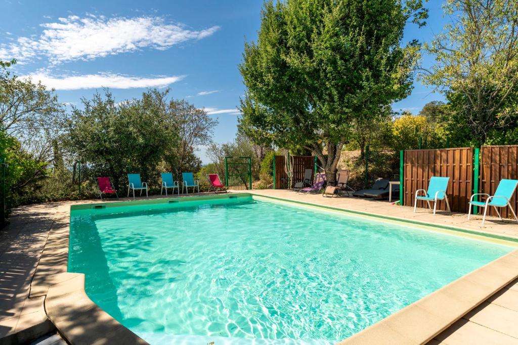 une piscine avec des chaises dans une cour dans l'établissement Les Conils, à Saint-Pierre-de-Vassols