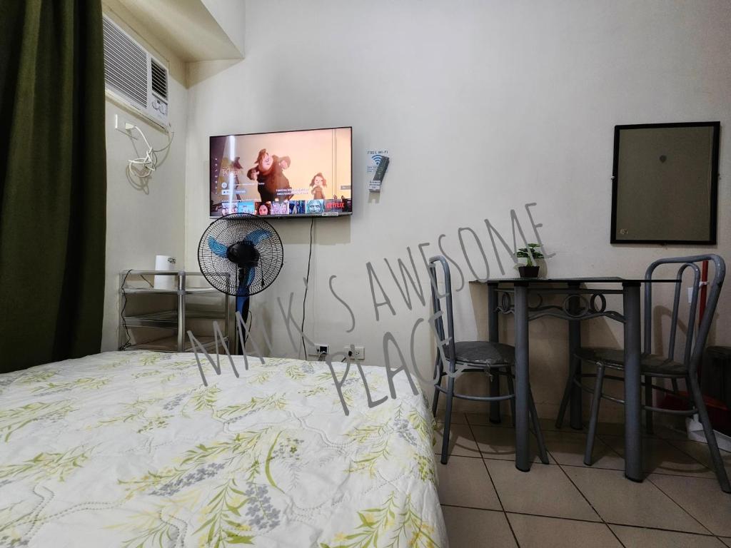 マニラにあるMacks Awesome 12 Place Fast Wifi Netflixのベッドルーム1室(ベッド1台、壁掛けテレビ付)