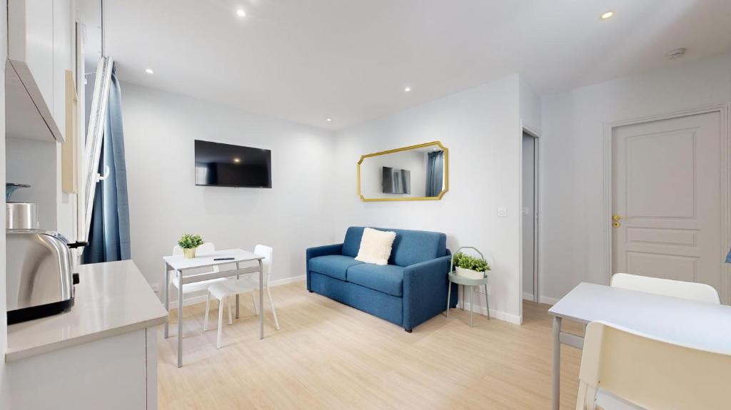 un salon avec une chaise bleue et une table dans l'établissement Bluestay 196 - Charmant Appartement au Marais, à Paris