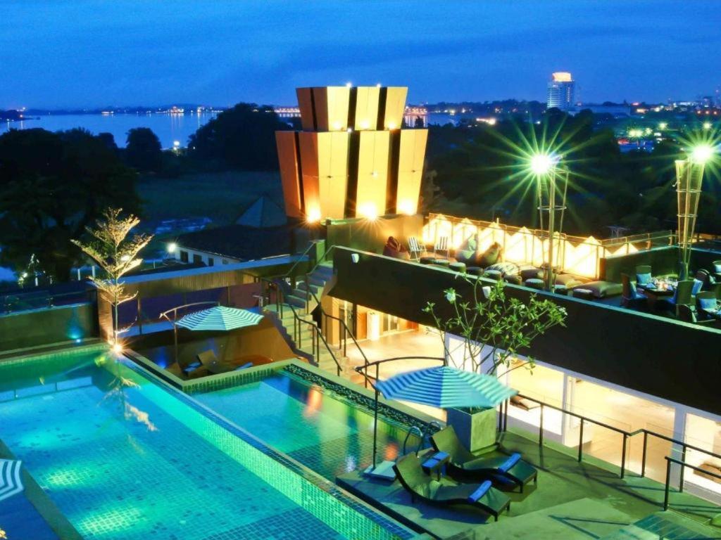 a pool on the roof of a building at night at Rashmi's Plaza Hotel Vientiane in Vientiane