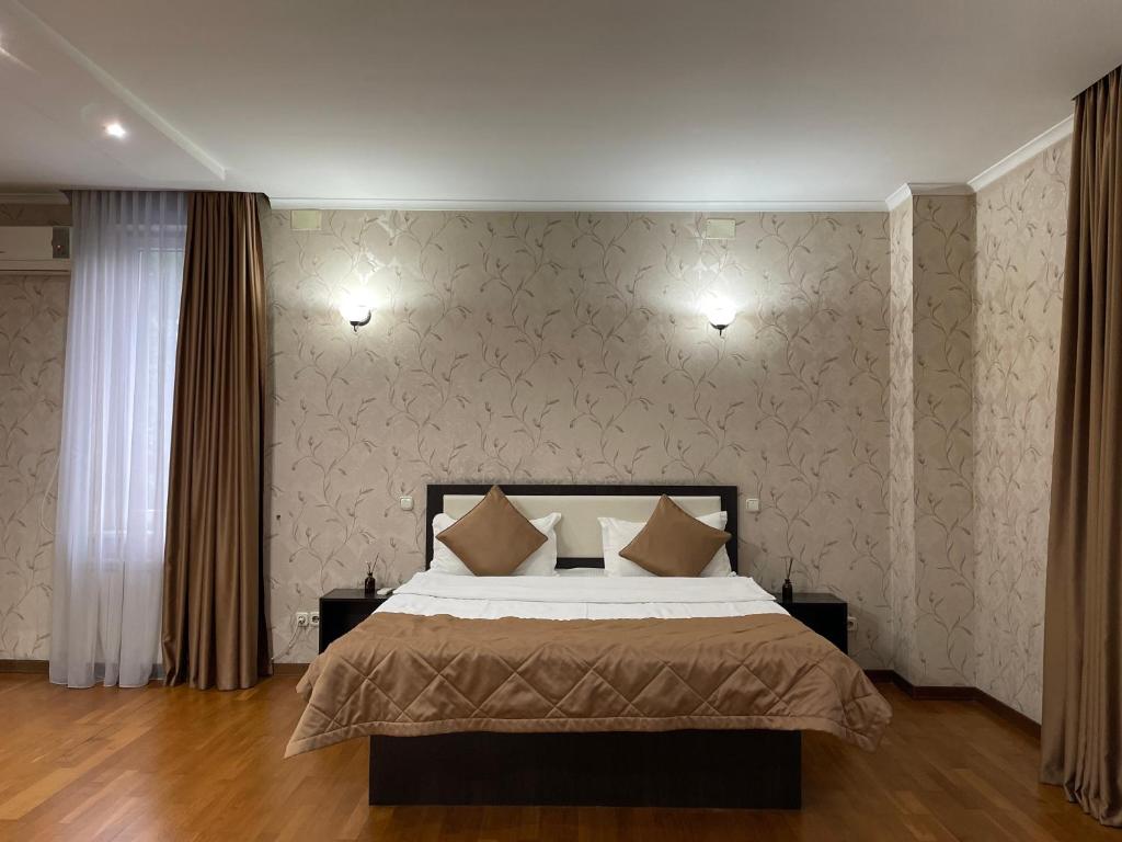 ein Schlafzimmer mit einem Bett und einer Tapetenwand in der Unterkunft Apart Hotel 5 in Almaty