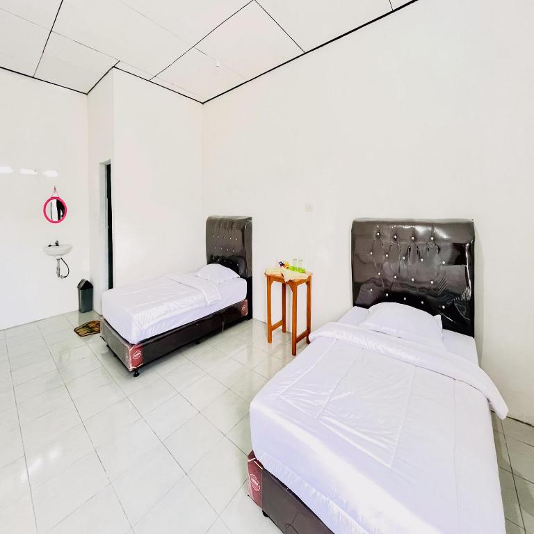 Postel nebo postele na pokoji v ubytování Kempu Tigan Homestay Berastagi Mitra RedDoorz