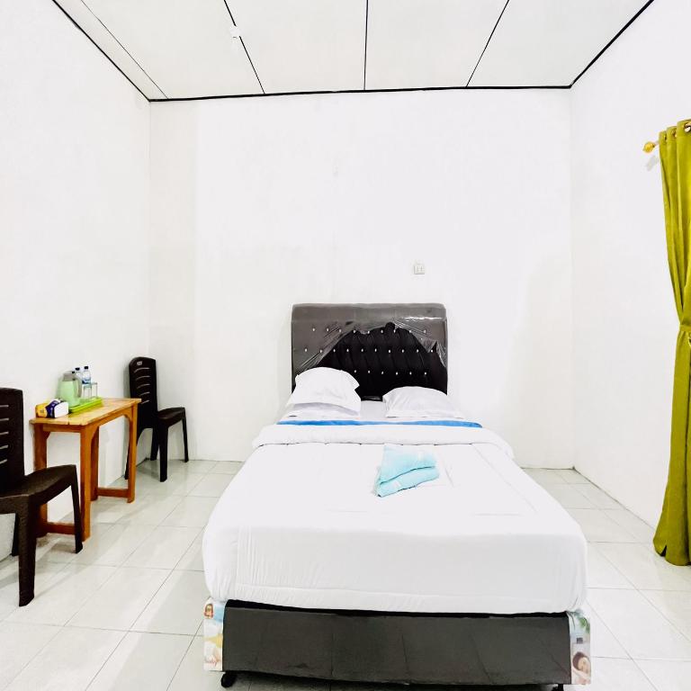 Postel nebo postele na pokoji v ubytování Kempu Tigan Homestay Berastagi Mitra RedDoorz