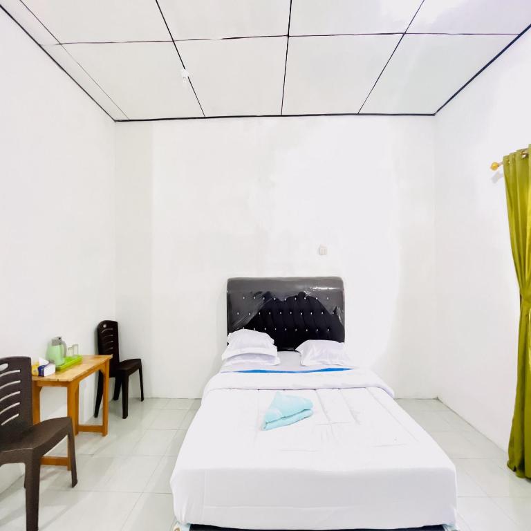 Postel nebo postele na pokoji v ubytování Kempu Tigan Homestay Berastagi Mitra RedDoorz