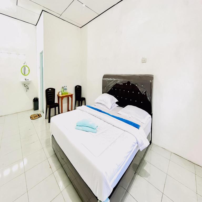 Postel nebo postele na pokoji v ubytování Kempu Tigan Homestay Berastagi Mitra RedDoorz