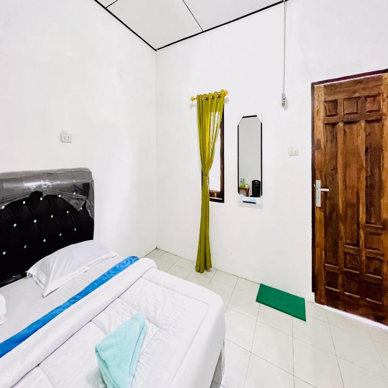 Postel nebo postele na pokoji v ubytování Kempu Tigan Homestay Berastagi Mitra RedDoorz
