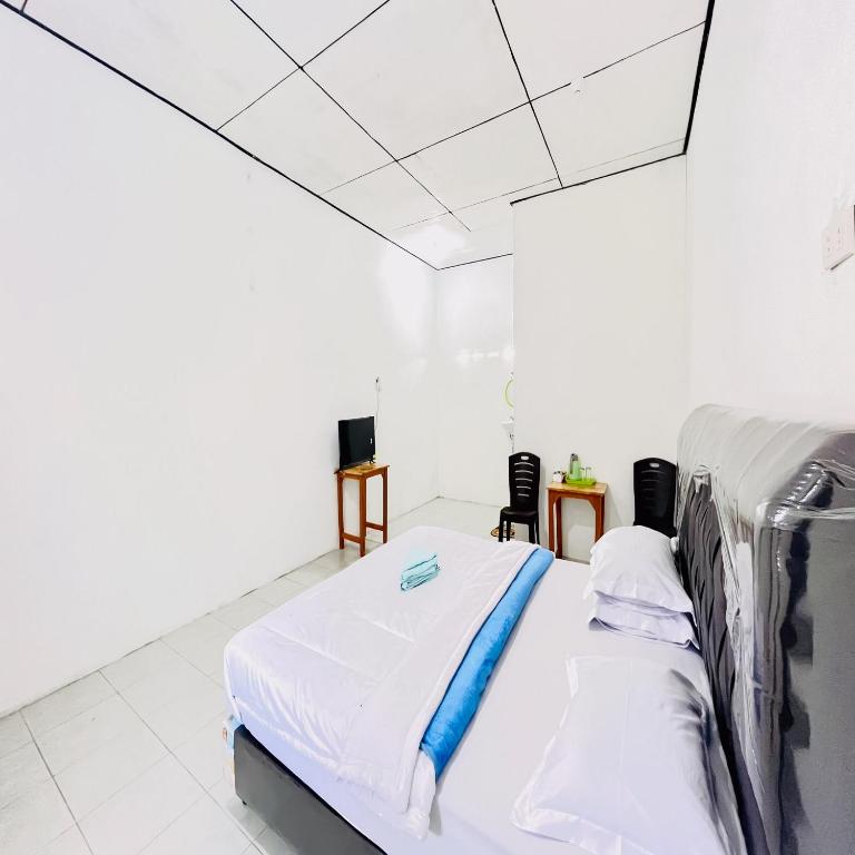 Postel nebo postele na pokoji v ubytování Kempu Tigan Homestay Berastagi Mitra RedDoorz