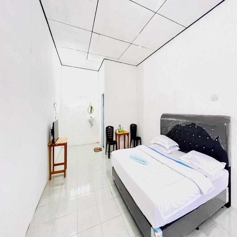 Postel nebo postele na pokoji v ubytování Kempu Tigan Homestay Berastagi Mitra RedDoorz