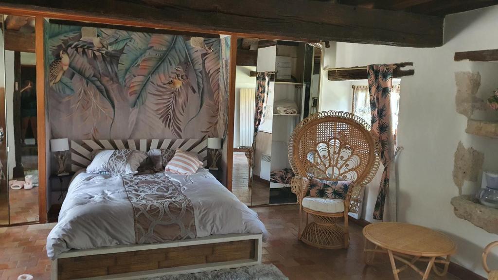 a bedroom with a bed and a table and chairs at Le domaine du chêne vert in Monthou-sur-Bièvre
