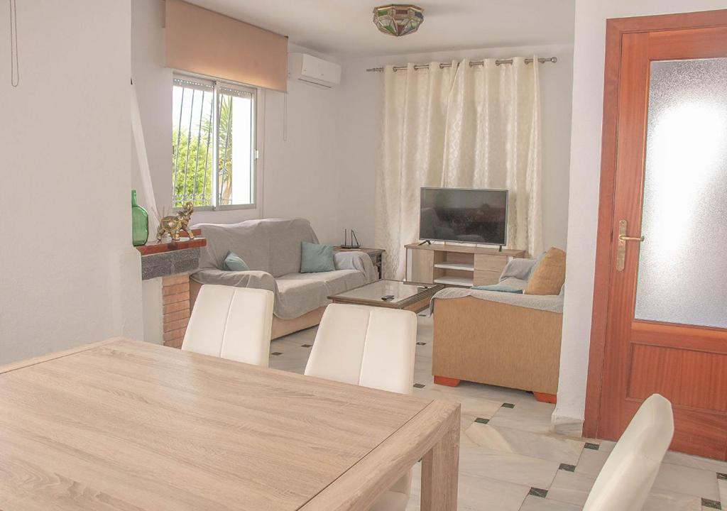 a living room with a table and chairs and a television at MojacarProperty, Casa Isabel Playa in La Marina de la Torre