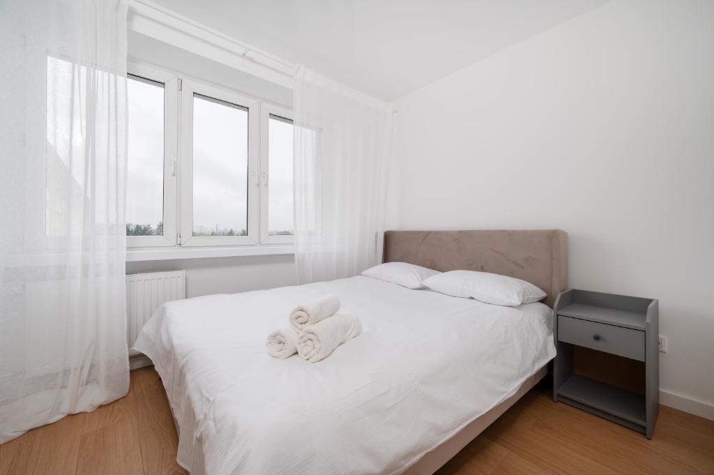 ein Schlafzimmer mit einem Bett, auf dem zwei Handtücher liegen in der Unterkunft Górna Pleasant Apartment in Rokicie