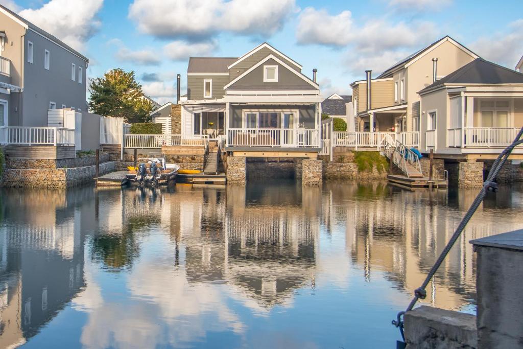a group of houses on a canal with a boat at Turbine Villa in Knysna