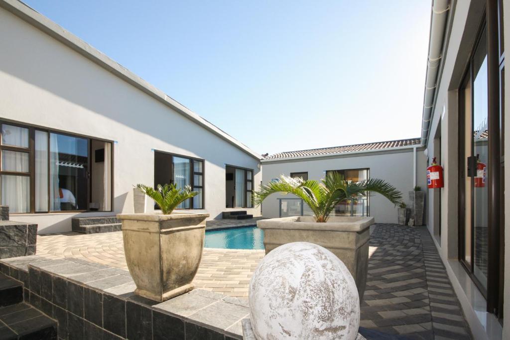 a courtyard of a house with a pool and plants at Le Blue Guesthouse in Port Elizabeth