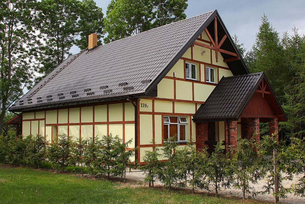 een geel en oranje huis met een zwart dak bij Holiday Home Adam in Szymki