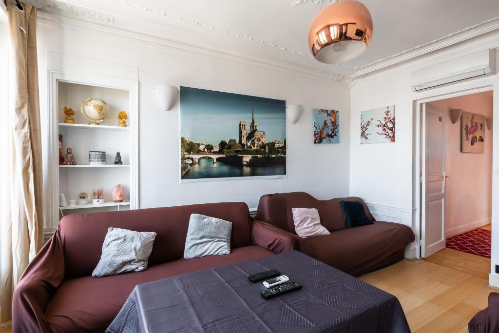 un salon avec un canapé et une table dans l'établissement Horizon des Fleurs - Paris 15 mn des Champs Élysée, à Paris