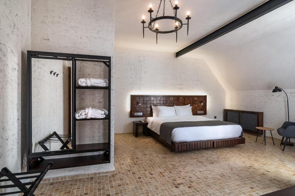 a bedroom with a large bed and a mirror at Kazma Boutique Hotel in Tbilisi City