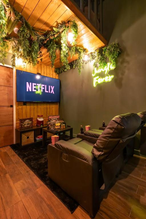 - un salon avec un panneau netflix sur le mur dans l'établissement Cinéroom - Jungle Fever, à Saint-Maur-des-Fossés