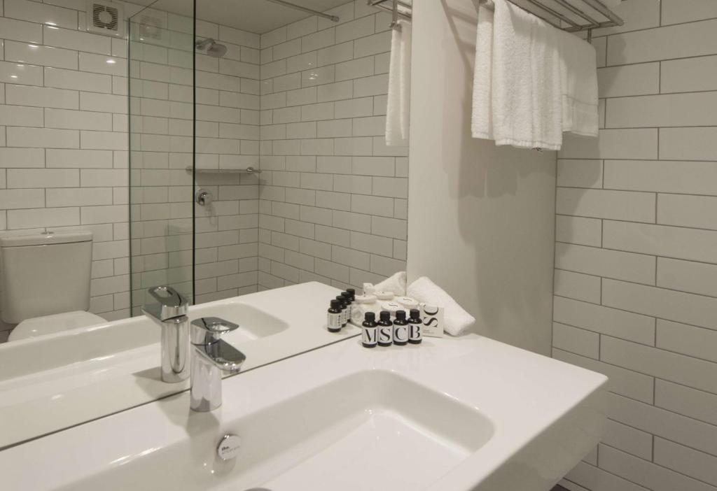 ロトルアにあるスディマ ホテル レイク ロトルアの洗面台とトイレを備えた白いバスルーム