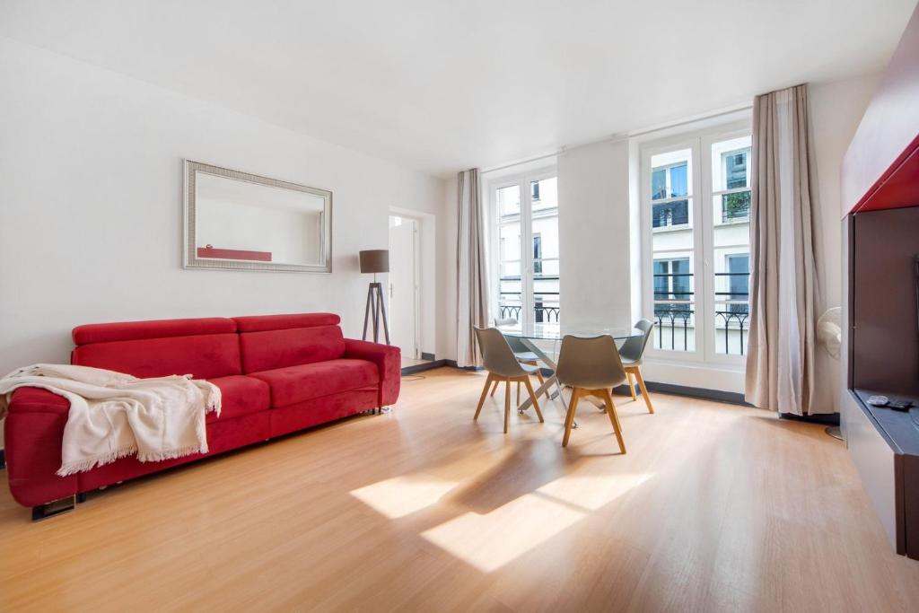 un salon avec un canapé rouge et une table dans l'établissement Paris Marais Maison Lombard, à Paris