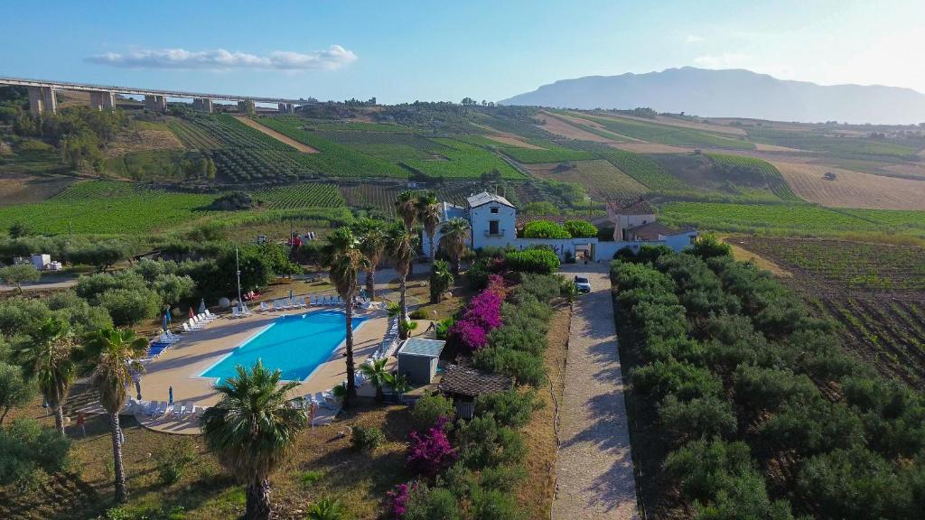 eine Luftaufnahme eines Resorts mit Pool und Palmen in der Unterkunft Fattoria Manostalla Villa Chiarelli in Balestrate